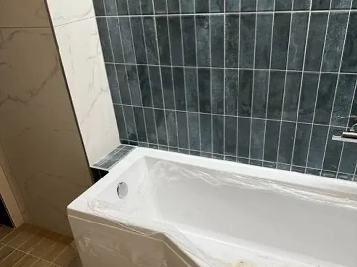 Nowa wanna przy granatowych płytkach — DobryHydraulik Poznań