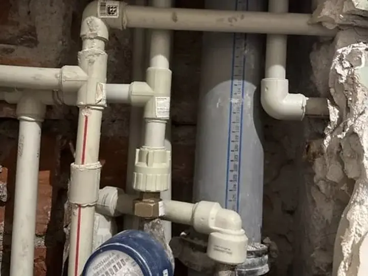 Wodomierz i stare rury w rozkutej ścianie — DobryHydraulik Poznań